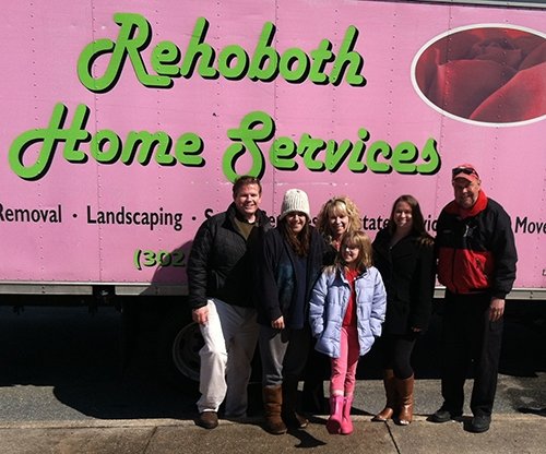 Family in front of large pink truck 