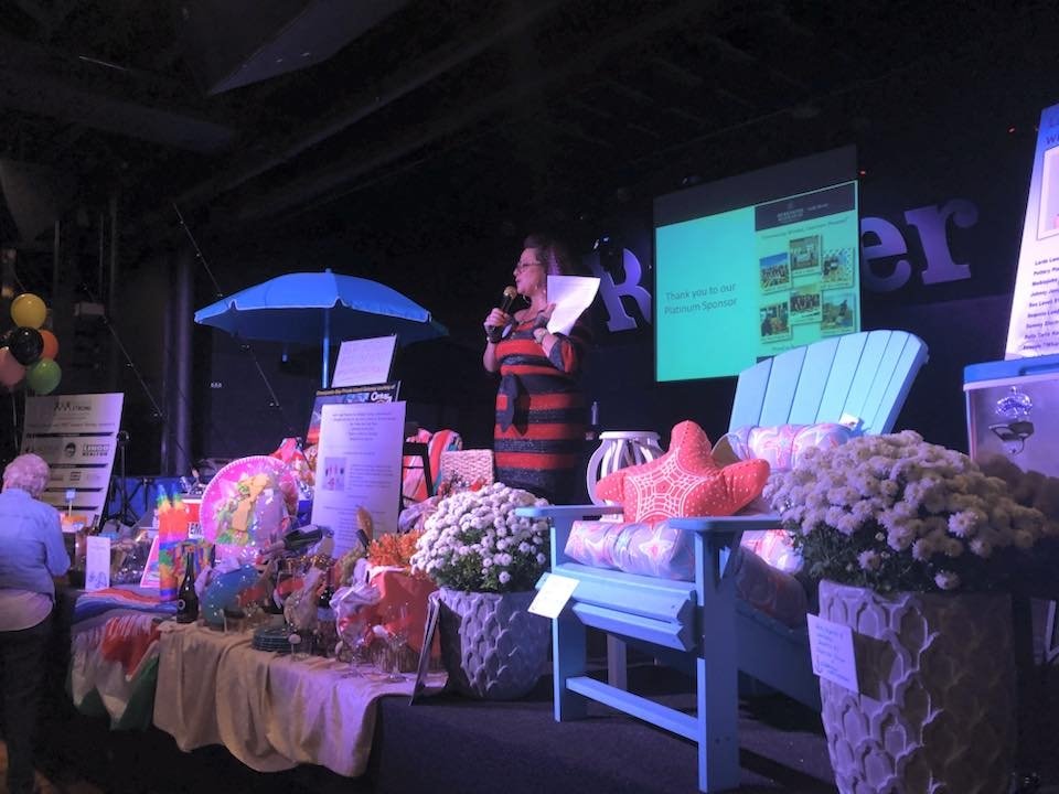 women auctioning off items for charity